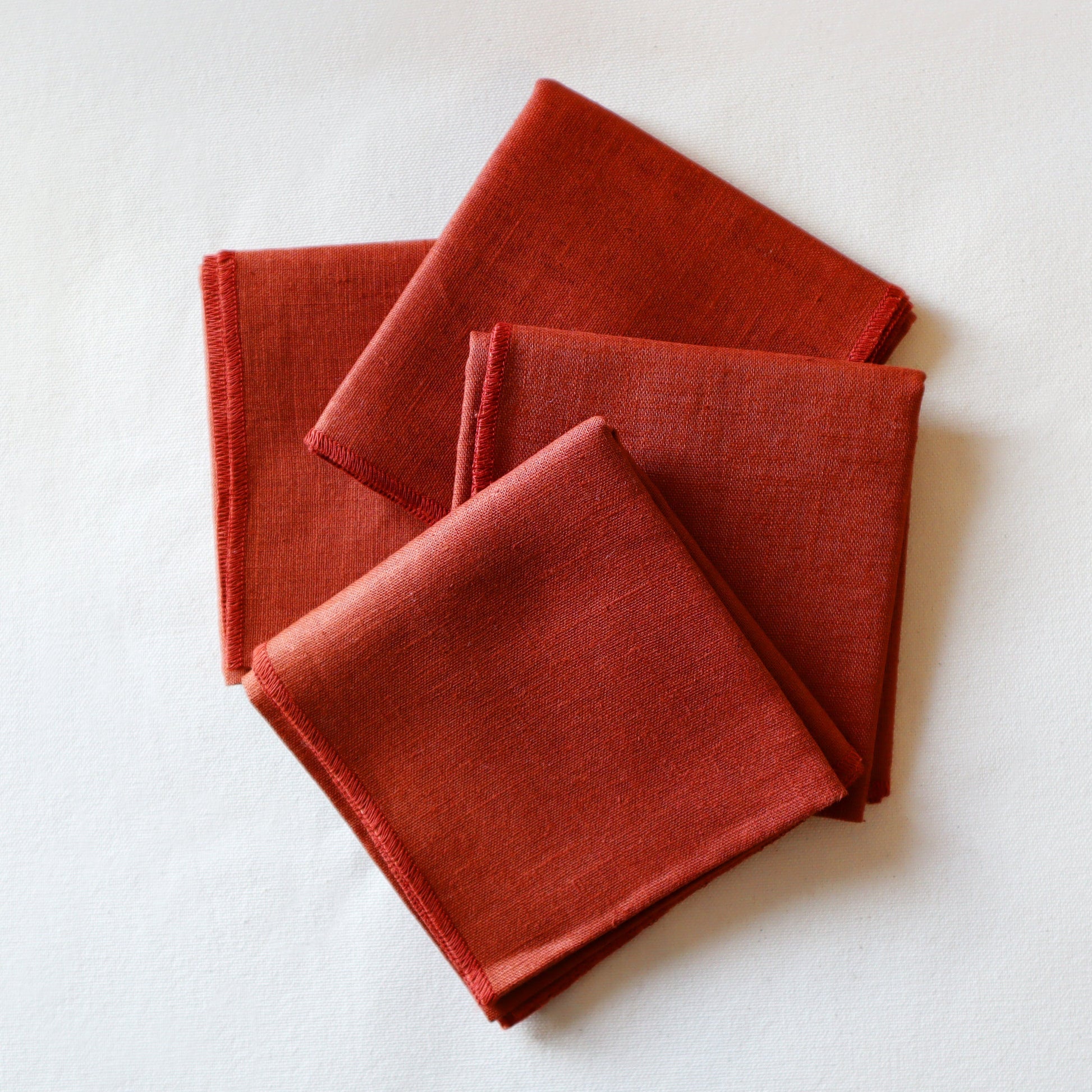 Three red fabric napkins stacked on a white background